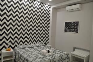 - une chambre dotée d'un lit avec un mur en damier noir et blanc dans l'établissement Il Corso Suite, à Rome