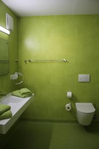 zieloną łazienkę z toaletą i umywalką w obiekcie Hotel/Pension Rast& Ruh w mieście Zodel