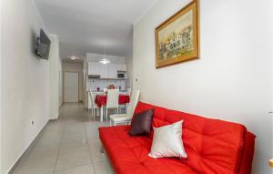 a living room with a red couch and a dining room at Lovely Apartment In Pinezici With Outdoor Swimming Pool in Pinezici