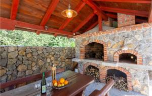 a stone patio with a table and a brick oven at Lovely Apartment In Pinezici With Outdoor Swimming Pool in Pinezici