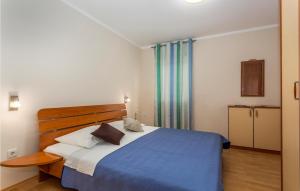 a bedroom with a blue bed with a wooden headboard at Awesome Apartment In Pinezici With Wifi in Pinezici