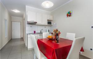 a kitchen with a red table and white chairs at Awesome Apartment In Pinezici With Wifi in Pinezici