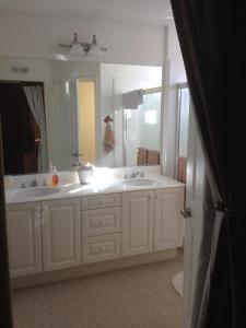 a bathroom with two sinks and a large mirror at Del Mar Heights Getaway in San Diego