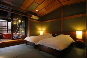 a bedroom with a bed with white sheets and a window at Hakone Fontaine Bleau Sengokutei in Hakone