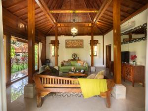 a living room with a couch and a bench at Tiis Garden Puri Villas in Gianyar