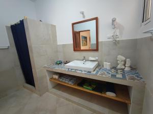 un bagno con lavandino e specchio di Casa Djarmai Apartments a Vila do Maio Altre 72 foto