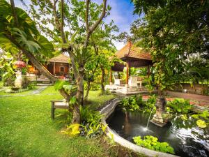a garden with a pond in the middle of a yard at Tiis Garden Puri Villas in Gianyar
