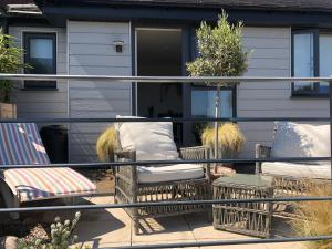 een balkon met 2 stoelen en een veranda met een huis bij Ocean Drive Boutique Apartment complimentary Tray in Brean