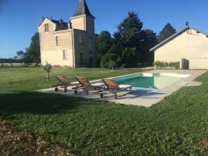 a group of benches sitting around a swimming pool in front of a building at Chateau des Barrigards in Ladoix Serrigny