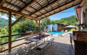 eine Außenterrasse mit einem Tisch und einem Pool in der Unterkunft Awesome Home In Plaski With Wifi in Plaški
