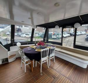 Yetkin Tekne في بودروم: غرفة طعام على قارب مع طاولة وكراسي