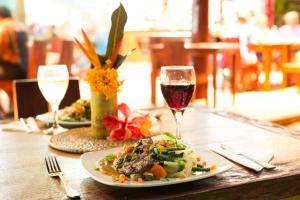 a table with a plate of food and a glass of wine at Mango Bay Resort in Namatakula