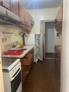 a small kitchen with a stove and a refrigerator at Temporada 3 quartos Localização central e nobre da Capital in Vitória