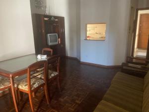 a dining room with a table and chairs and a tv at Temporada 3 quartos Localização central e nobre da Capital in Vitória