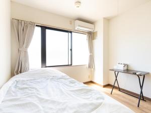 a bedroom with a bed and a window at Tabist Daibou Ichihara Mens Only in Ichihara