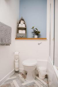 uma casa de banho com WC e uma prateleira na parede em Barry Island Beachfront Apartment - Stunning Bay Views and Private Parking em Barry
