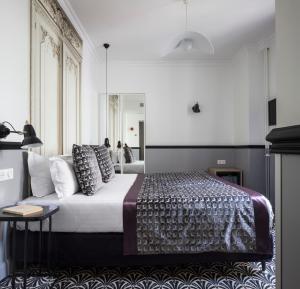 a bedroom with a large bed with pillows on it at Hotel Malte - Astotel in Paris