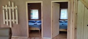 two beds in a room with two windows at Sodyba Žaliasis slėnis Anykščiuose in Anykščiai