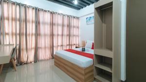 1 dormitorio con cama y estante para libros en RedDoorz Near Iloilo International Airport en Iloílo