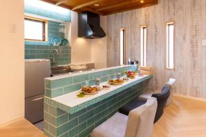uma cozinha com uma mesa com pratos de comida em ADAN RESORT 風 - Fu - em Bise