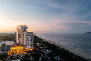 Hoiana Hotel & Suites في هوي ان: مبنى طويل بجوار الشاطئ عند غروب الشمس
