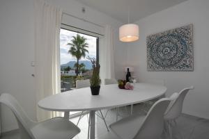 ein weißes Esszimmer mit einem weißen Tisch und Stühlen in der Unterkunft Corto in Denia