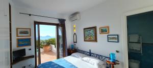 a bedroom with a bed and a door to a balcony at Guest House Villa Il Gabbiano in Ponza