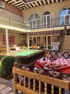 un patio con una mesa y una piscina en SHAHNOZA GRAND en Samarcanda