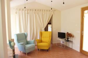a living room with two chairs and a television at Casa Barulli - Tuscany in San Giovanni Valdarno