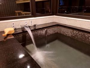 a bathroom with a sink with a water fountain at 秒飛日本 頭城小京都町家溫泉之宿 in Toucheng