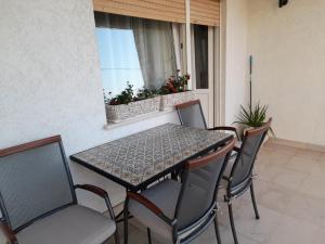 a table and chairs on a patio with a window at Apartment Sladojevic in Omiš
