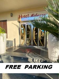 un hotel con una señal de aparcamiento gratuito frente a un edificio en Hotel Milazzo, en Milazzo