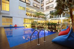 un hotel con piscina y un edificio en ibis Styles Jakarta Gajah Mada, en Yakarta