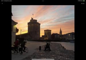 two people riding bikes in a city at sunset at Appartement plein centre de la ROCHELLE in La Rochelle +6 photos