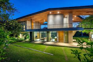 a large house with a balcony and a yard at Gliding Villa in Khao Yai in Mu Si