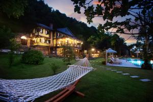 Casa Giallo Managed By Dedeman في صبنجة: أرجوحة أمام المنزل مع مسبح