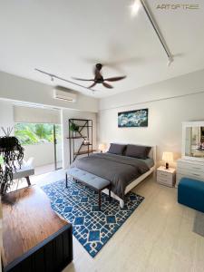 By The Sea Beachfront Designer Suites Penang - Managed by Art of Tree في باتو فيرينغي: غرفة نوم بسرير وسجادة زرقاء