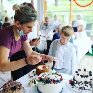 a woman is cutting a cake with a knife at Pension Restaurant Luna in Treis-Karden