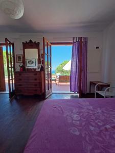 Schlafzimmer mit einem Bett und einer Tür zu einem Balkon in der Unterkunft Padullella, mare e sole!! in Portoferraio