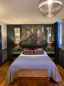 1 dormitorio con 1 cama grande y una pintura en la pared en Hotel Boutique Balaitus en Sallent de Gállego
