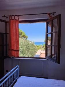 a room with a window with a view of the ocean at Padullella, mare e sole!! in Portoferraio