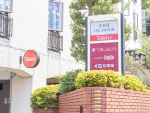 una señal para un hotel frente a un edificio en Tabist Sasebo Palace Hotel, en Sasebo