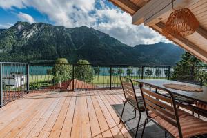 una terraza con mesa, sillas y montañas en Seeblickwohnung Liesl, en Buchau