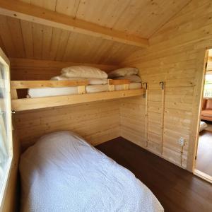 a small room with a bed in a wooden cabin at Vakantiehuisje met keuken, 2 slaapkamers en woonkamer in Zwiggelte