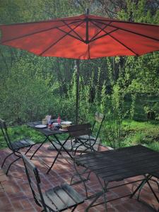 una mesa y sillas bajo una sombrilla en un patio en Privelacker Paradiesgarten 