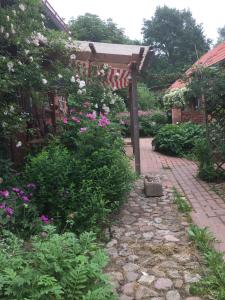 un jardín con flores y una pasarela de ladrillo en Privelacker Paradiesgarten 