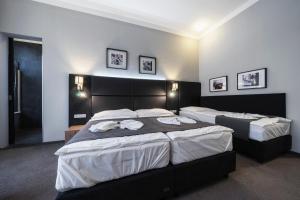a bedroom with two beds with towels on them at Hotel NOIR in Prague