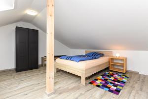 a bedroom with a bed and a wooden floor at Ferienwohnungen Haus Hasenweide in Stedesdorf