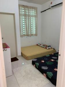 a bedroom with two beds in a room with a window at Hadeerna Homestay - Double storey terrace in Chemor