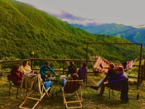 a group of people sitting in chairs in front of a mountain at Qaldea Resort in Ushguli